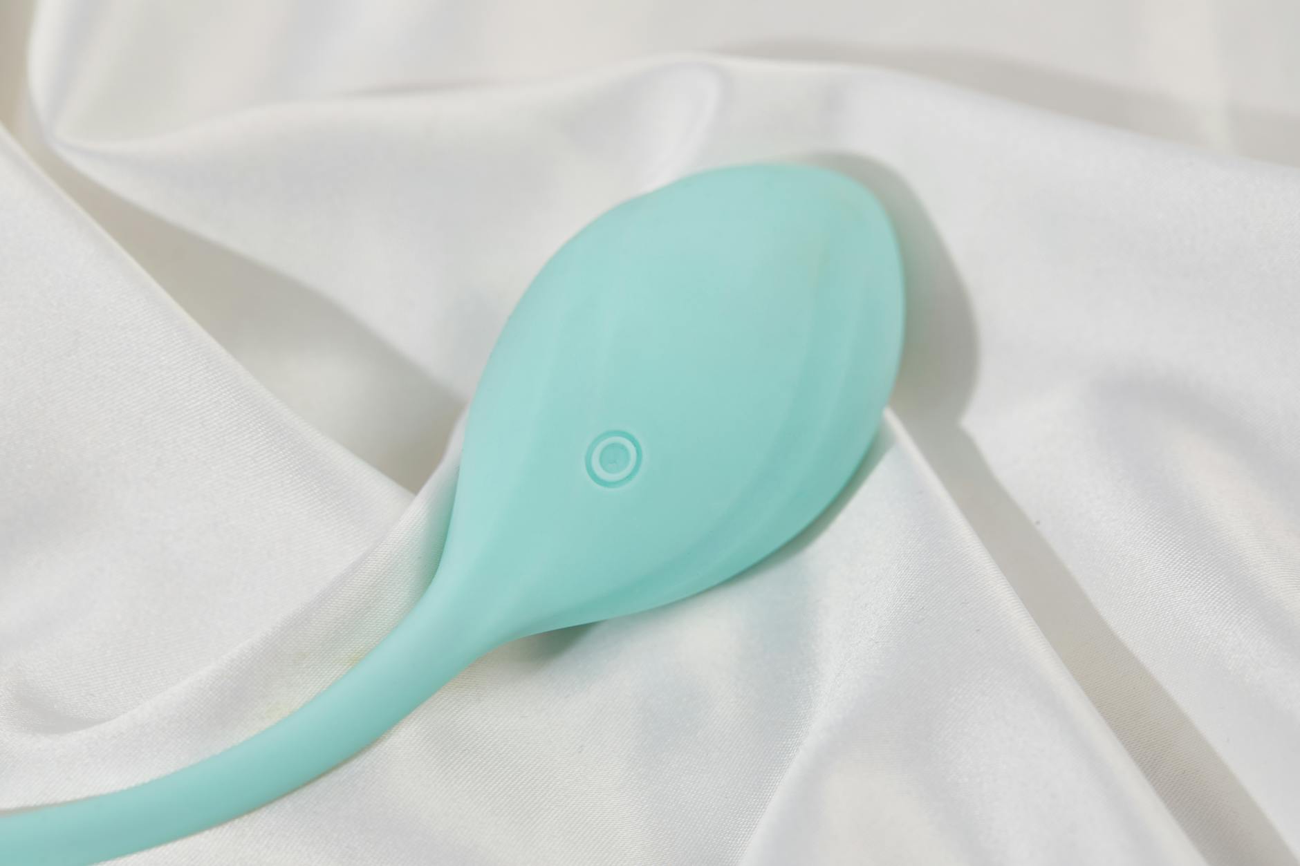 Un elegante vibratore blu su morbido tessuto di seta bianca