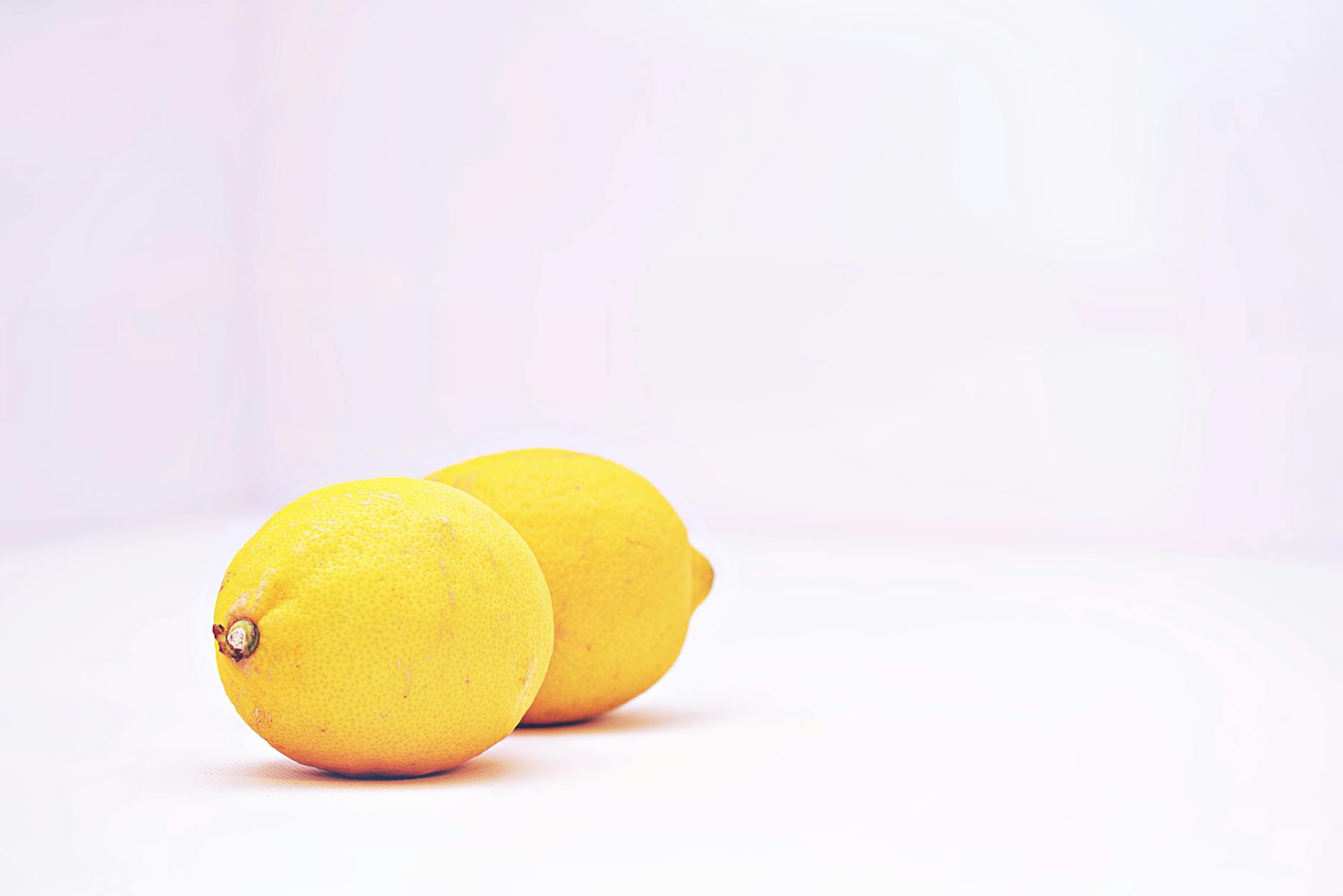Two fresh lemons on a white background, symbolizing a clean start and renewed vitality