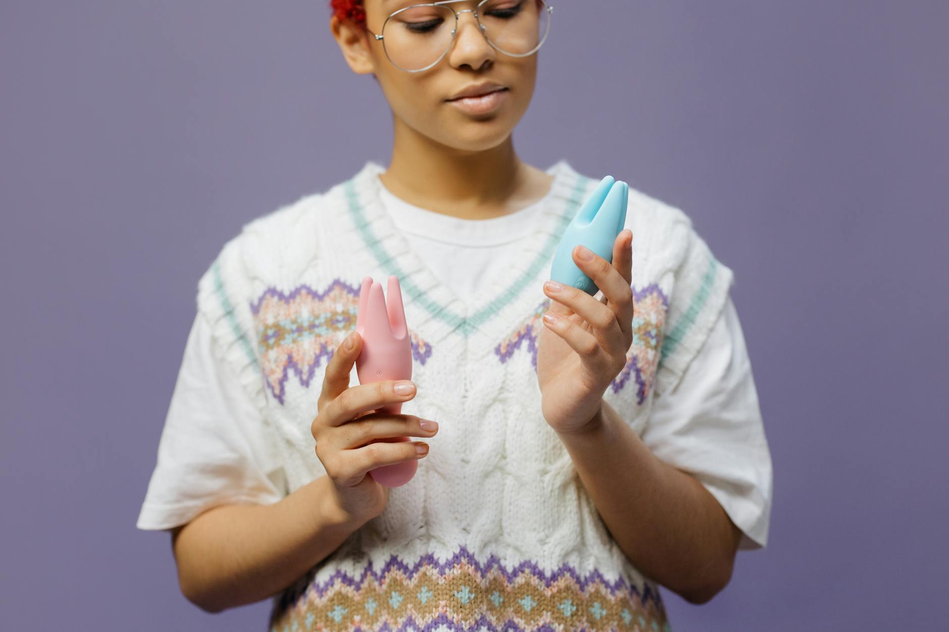 A young couple standing together indoors, holding a blue vibrator, symbolizing modern intimacy and connection.