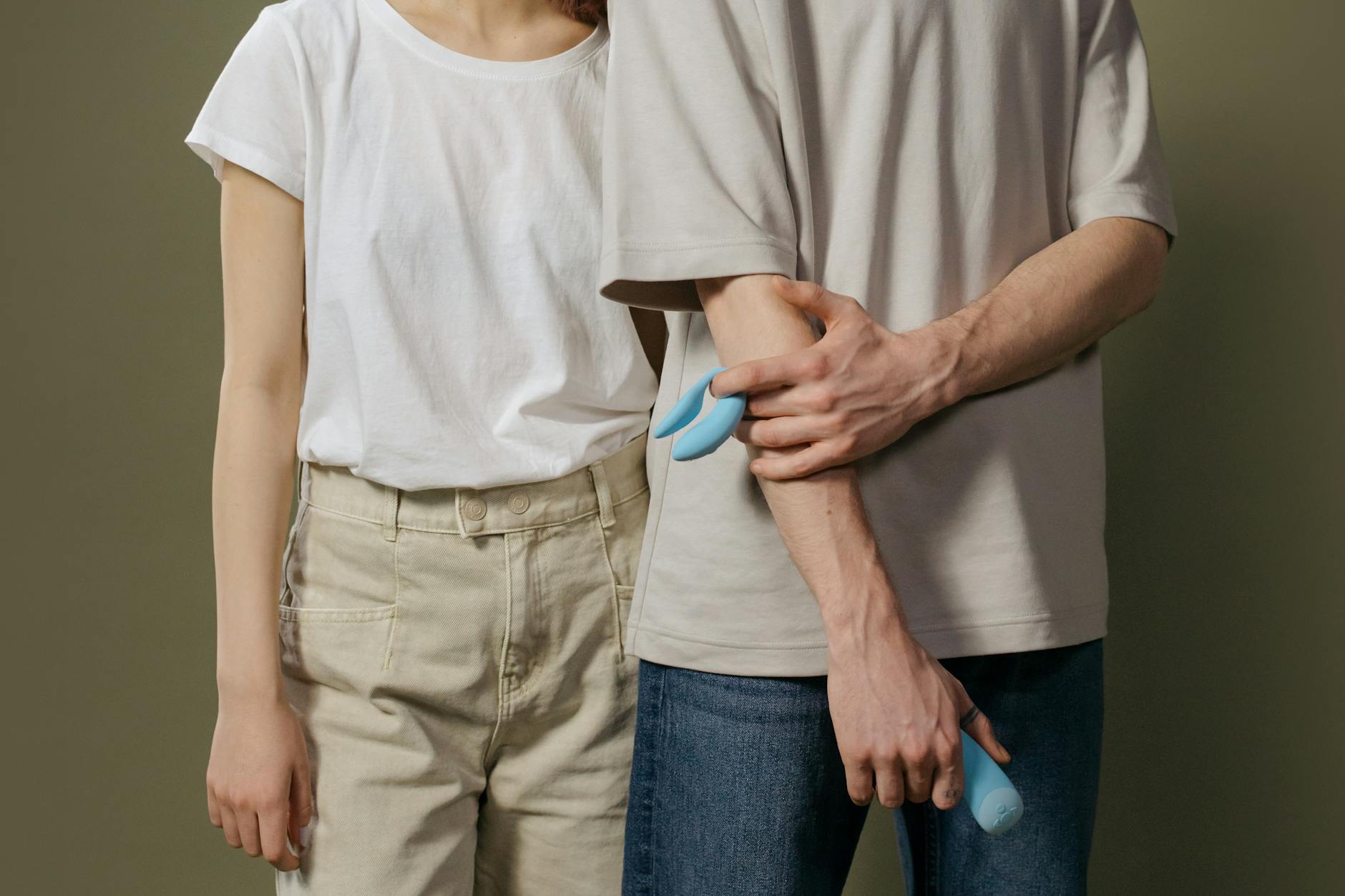 A couple holding a blue vibrator together, representing modern intimacy and shared pleasure with quality adult toys.
